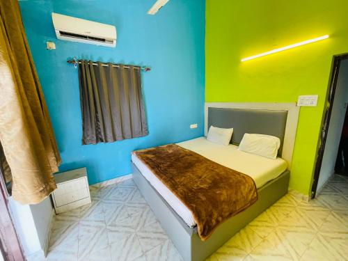 ein Schlafzimmer mit einem Bett in einer blauen und grünen Wand in der Unterkunft Js Private villa with pool in Calangute