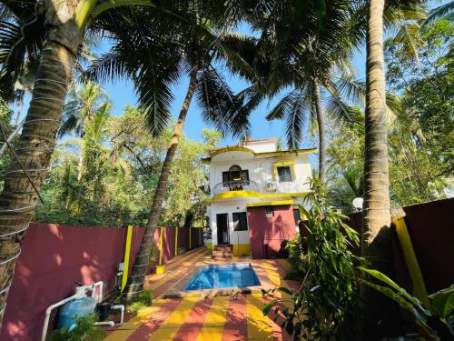 ein Haus mit einem Pool vor Palmen in der Unterkunft Js Private villa with pool in Calangute