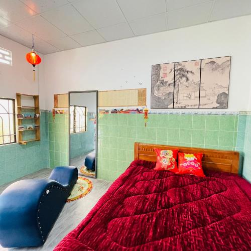1 dormitorio con 1 cama grande y edredón rojo en Nhà nghỉ Bảo Trâm, en Chau Doc