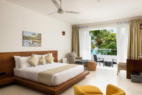 a bedroom with a bed and a living room at Vis Ta Vie -Thema Collection in Mirissa