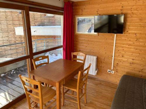 a dining room with a table and chairs and a television at Appartement Chamrousse, 4 personnes - Village du Bachat in Chamrousse