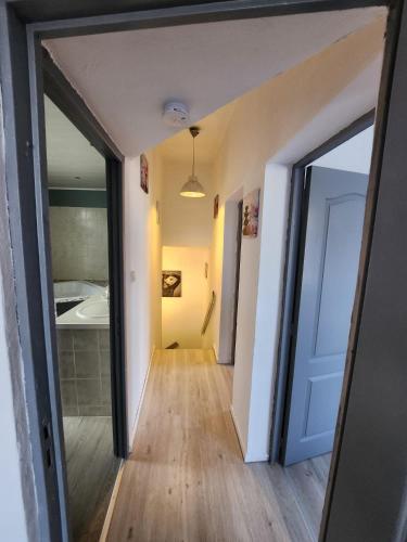 un couloir avec une porte menant à une salle de bains. dans l'établissement Maison 8 personnes, à Vendin-le-Vieil