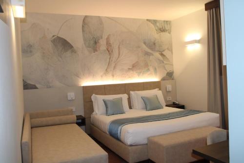 a hotel room with a bed and a painting on the wall at Hotel Marzia in Scandicci