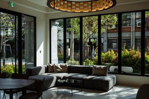 a living room with a couch and a table and windows at XIUXI Anping Hotel in Anping