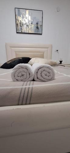 a white bed with towels on top of it at RutSuite in El ‘Affūle