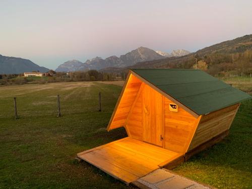 una casa de perros de madera en un campo con montañas en el fondo en Agriturismo Modolo, 