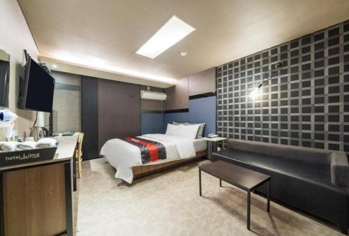ein Hotelzimmer mit einem Bett und einem TV in der Unterkunft Lime hotel in Suwon
