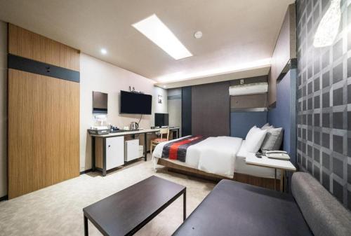 Habitación grande con cama y mesa en Lime hotel, en Suwon