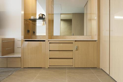 a kitchen with wooden cabinets and a counter top at Hotel Regent Marine The Blue in Jeju