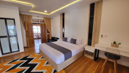 sypialnia z dużym łóżkiem i biurkiem w obiekcie Kelong Pancing Madu Tiga w mieście Tanjungpinang