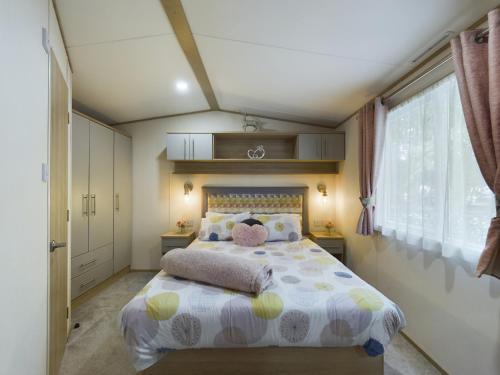 a bedroom with a bed and a large window at Tattershall Lakes Mini Breaks - The Avenue in Lincoln