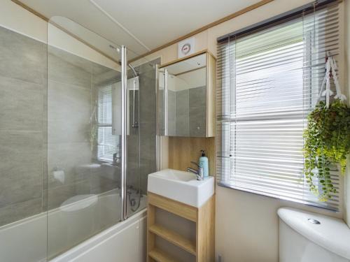 a bathroom with a sink and a shower and a mirror at Tattershall Lakes Mini Breaks - The Avenue in Lincoln