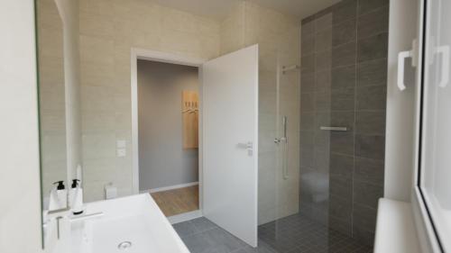 a bathroom with a white sink and a shower at Adapt Apartments Wetzlar in Wetzlar