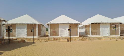 a row of tents in the middle of the desert at Robin Desert Safari Camp in Jaisalmer