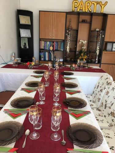 - une longue table avec des verres à vin et des assiettes dans l'établissement MYONNA Style Slobozia, 