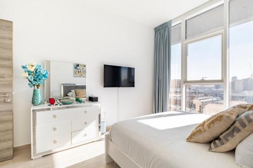 - une chambre blanche avec un lit et une fenêtre dans l'établissement Dubai Dreamland 1BR for 4, King Bed, Pool, Sauna, Gym, Free Parking, à Dubaï