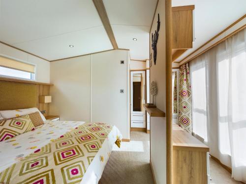 1 dormitorio con cama y ventana grande en Tattershall Lakes Mini Breaks - Osprey Rise, en Tattershall