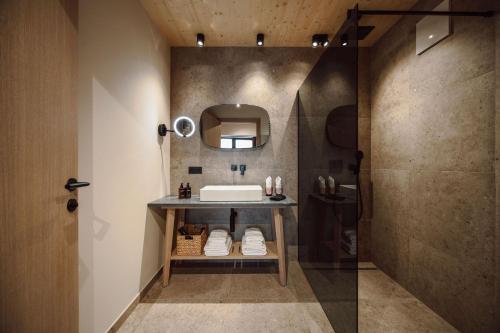 a bathroom with a sink and a mirror at Boutique Hotel Das Rivus in Leogang