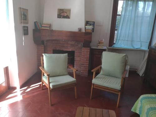 a living room with two chairs and a fireplace at Padullella, mare e sole!! in Portoferraio