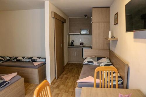 mały apartament z 2 łóżkami, stołem i krzesłami w obiekcie Penzion Kotvas w mieście Milovice