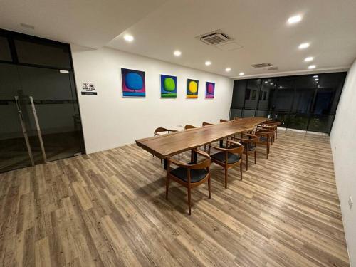 a conference room with a long wooden table and chairs at LV Homestay @ Gala Residence in Kuching