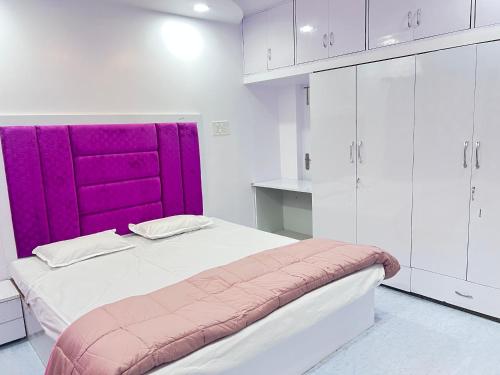 um quarto com uma cama com uma cabeceira roxa em Twin Room em Nagpur