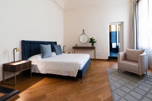 a bedroom with a large bed and a chair at The Seven Residence in Genova