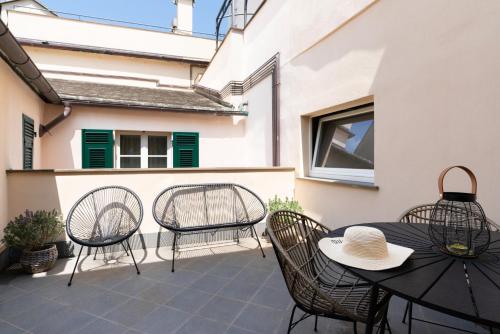 a patio with three chairs and a table and a table and chairs at The Seven Residence in Genoa