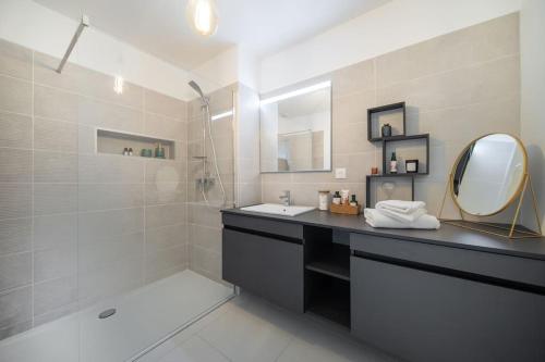 une salle de bain avec un lavabo, un miroir et une douche dans l'établissement Le Square d'Evan - Appartement de Standing - Grande Terrasse Extérieure - Climatisation, à Saint-Aunès