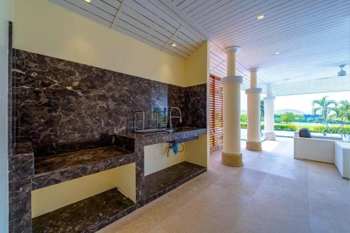 een badkamer met een stenen muur en een wastafel bij Luxury Mansion On Black Mountain Golf Course(BMG5) in Hua Hin