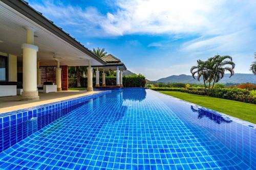 a swimming pool in front of a house at Luxury Mansion On Golf Course BMG5 in Hua Hin