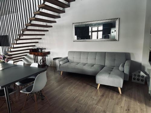 a living room with a couch and a staircase at Apartmány 400 in Veľká Lomnica