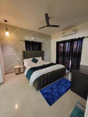 a bedroom with a large bed with a blue rug at THE PERFECT STAYS: SUPREME BLISS VILLA in Lonavala