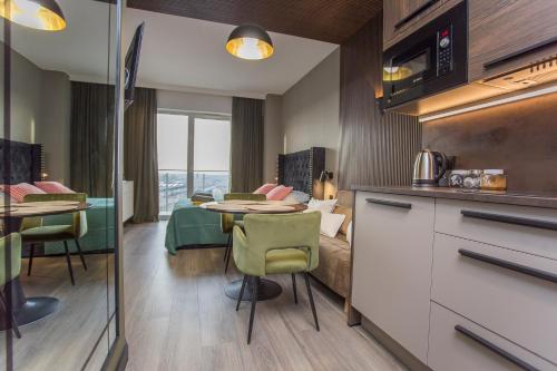 a room with a kitchen and a bedroom with a table at Urban Jungle apartament Epsilon in Białystok