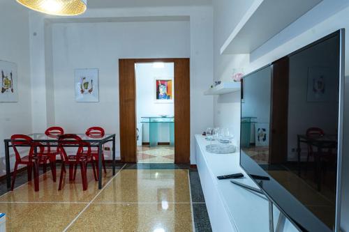 uma cozinha e sala de jantar com mesa e cadeiras vermelhas em La Casa di Sissi em La Spezia