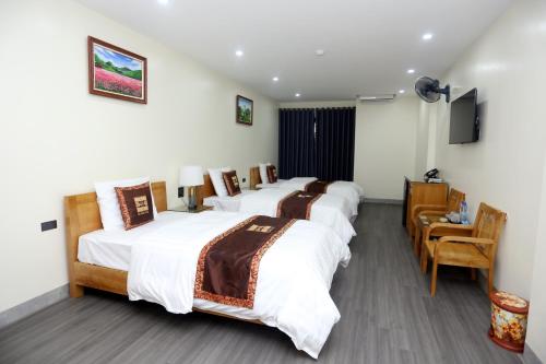 a hotel room with four beds and a television at HOA CƯƠNG HOTEL 2 (HÀ GIANG) in Ha Giang