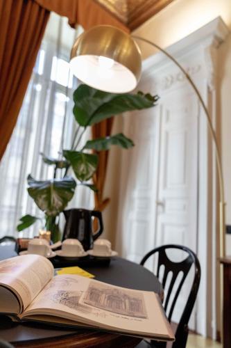 an open book on a table with a lamp at Hotel Bologna in Turin