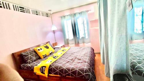 Un dormitorio con una cama con un tren amarillo. en Rianne's transient house, en Puerto Princesa City