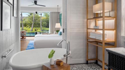 y baño con 2 camas, lavamanos y bañera. en Kimpton Kitalay Samui, an IHG Hotel en Choeng Mon Beach