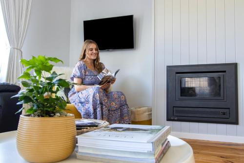 a woman sitting in a living room holding a dog at Owl+Oak in Castlemaine