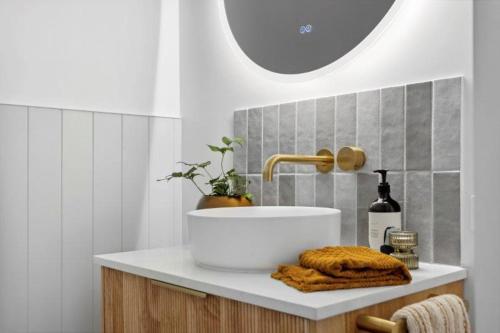 a bathroom with a sink and a bottle of wine at Owl+Oak in Castlemaine