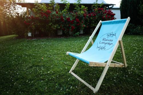a chair with a sign on it sitting in the grass at RanczoLatyczyn 