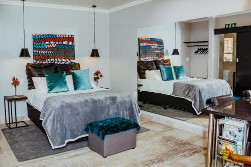 a bedroom with two beds with blue pillows at Ons Dorpshuis Guesthouse in Rustenburg
