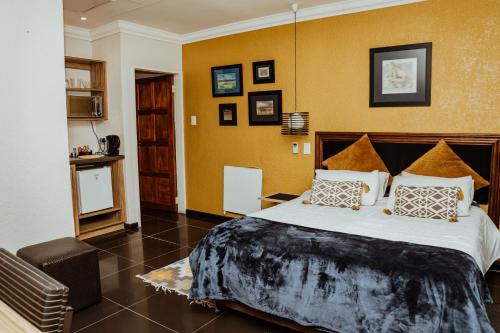 a bedroom with a large bed in a room at Ons Dorpshuis Guesthouse in Rustenburg