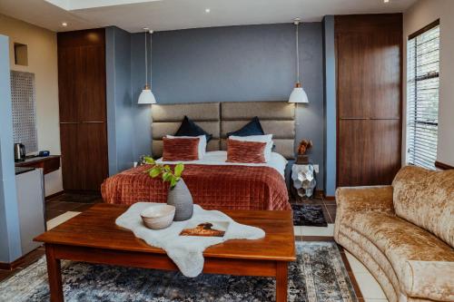 um quarto de hotel com uma cama e uma mesa em Ons Dorpshuis Guesthouse em Rustenburg