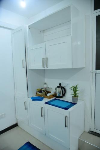 a white kitchen with white cabinets and a tea kettle at Ocean View Villa in Hikkaduwa
