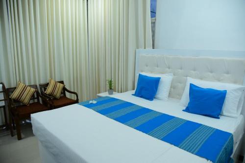 a bedroom with a large bed with blue pillows at Ocean View Villa in Hikkaduwa