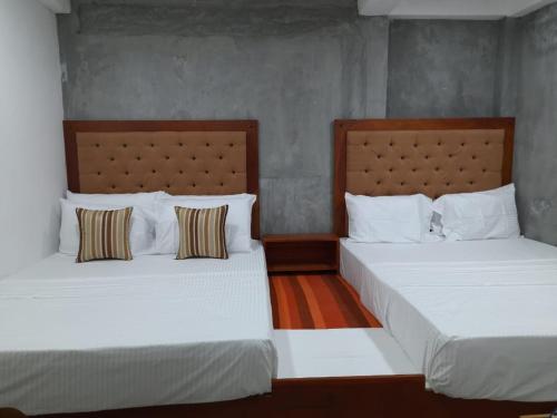two beds sitting next to each other in a bedroom at Ocean View Villa in Hikkaduwa