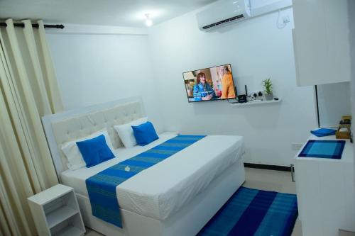 a bedroom with a large white bed with blue pillows at Ocean View Villa in Hikkaduwa