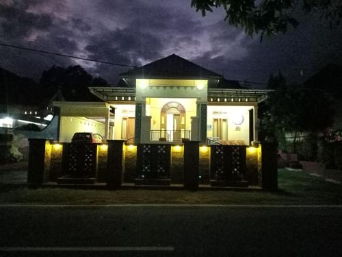 una casa iluminada por la noche con luces en Wambuliga Homestay en Waha